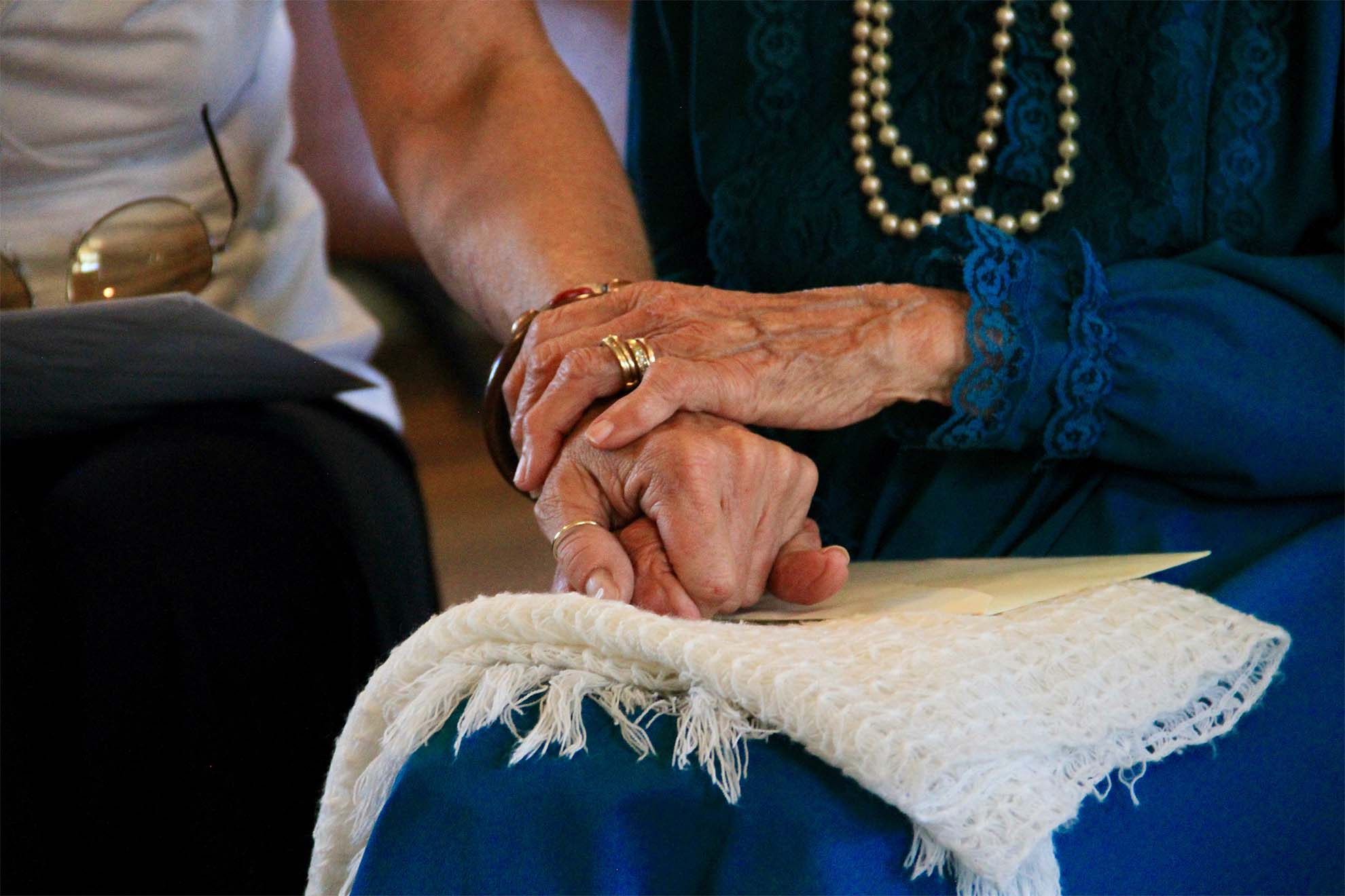 resident and loved ones holding hands