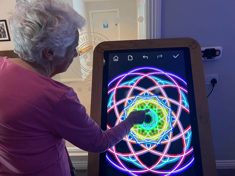 female resident using an interactive tablet in the sensory room