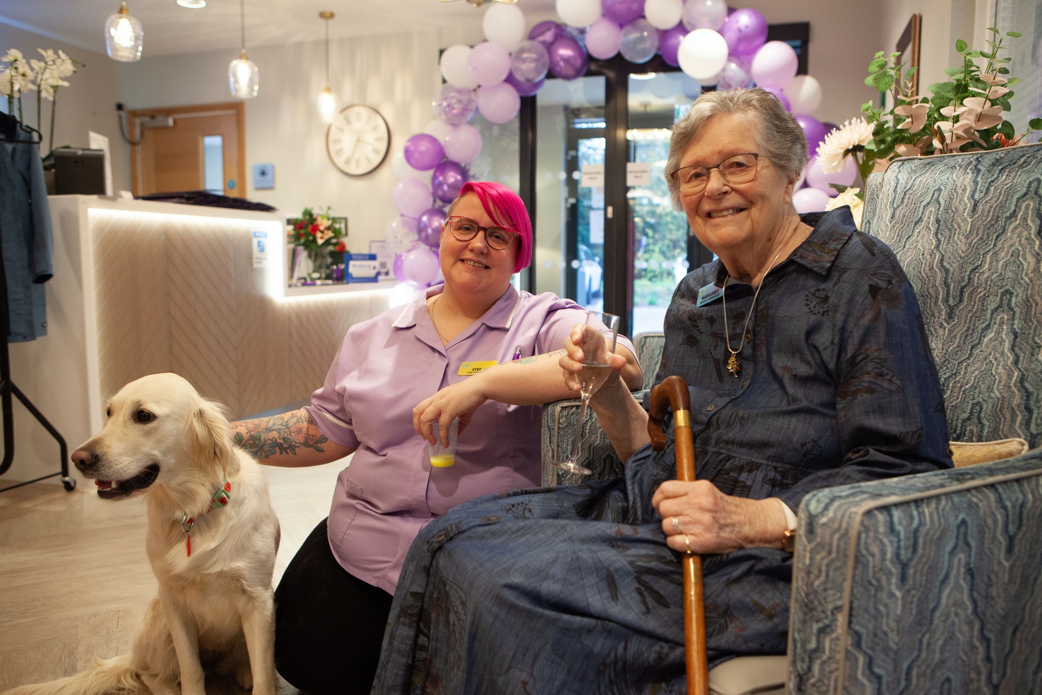 resident and carer sat together enjoying a drink