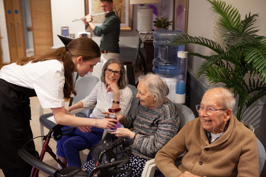 resident being given a cupcake by the kitchen team