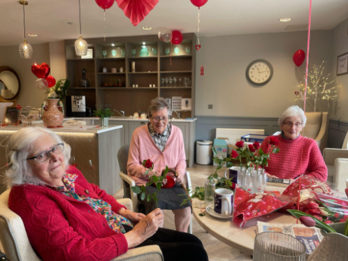 three female residents sat around a table together enjoying valentines celebrations