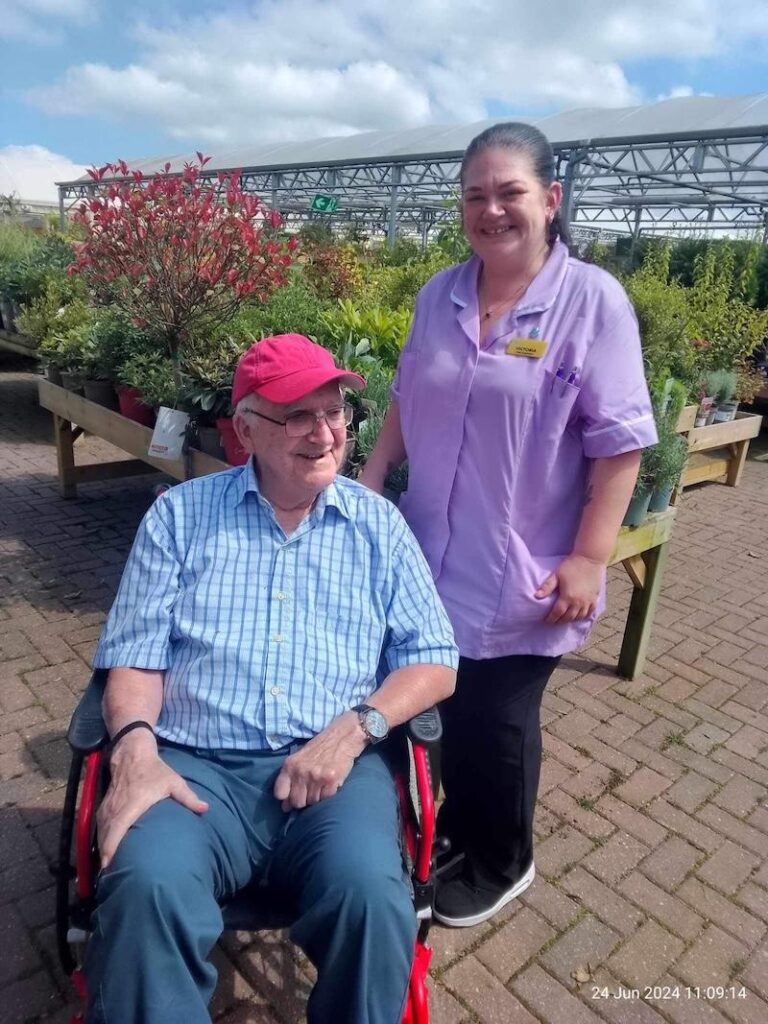 resident with a carer at the garden centre