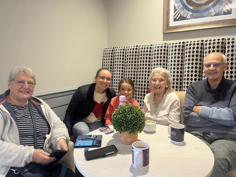 a group photo of our residents and their loved ones in our cafe area