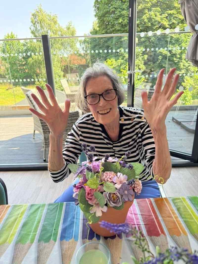 one of our residents wearing a striped top doing flower arranging