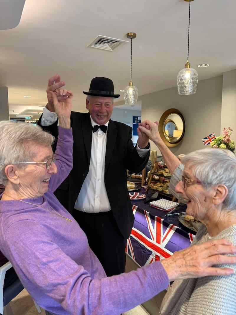 2 of our female residents dancing together with one of our activities coordinators