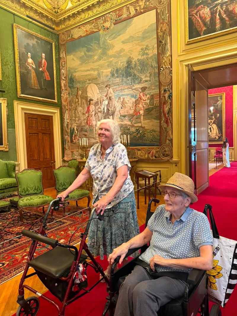 2 of our residents on an outing looking at paintings on the wall