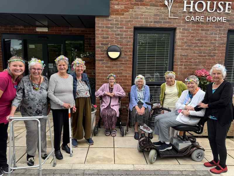 a group of our residents wearing flower crowns stood outside our home
