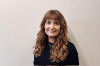 a lady with brown hair posing for staff photo
